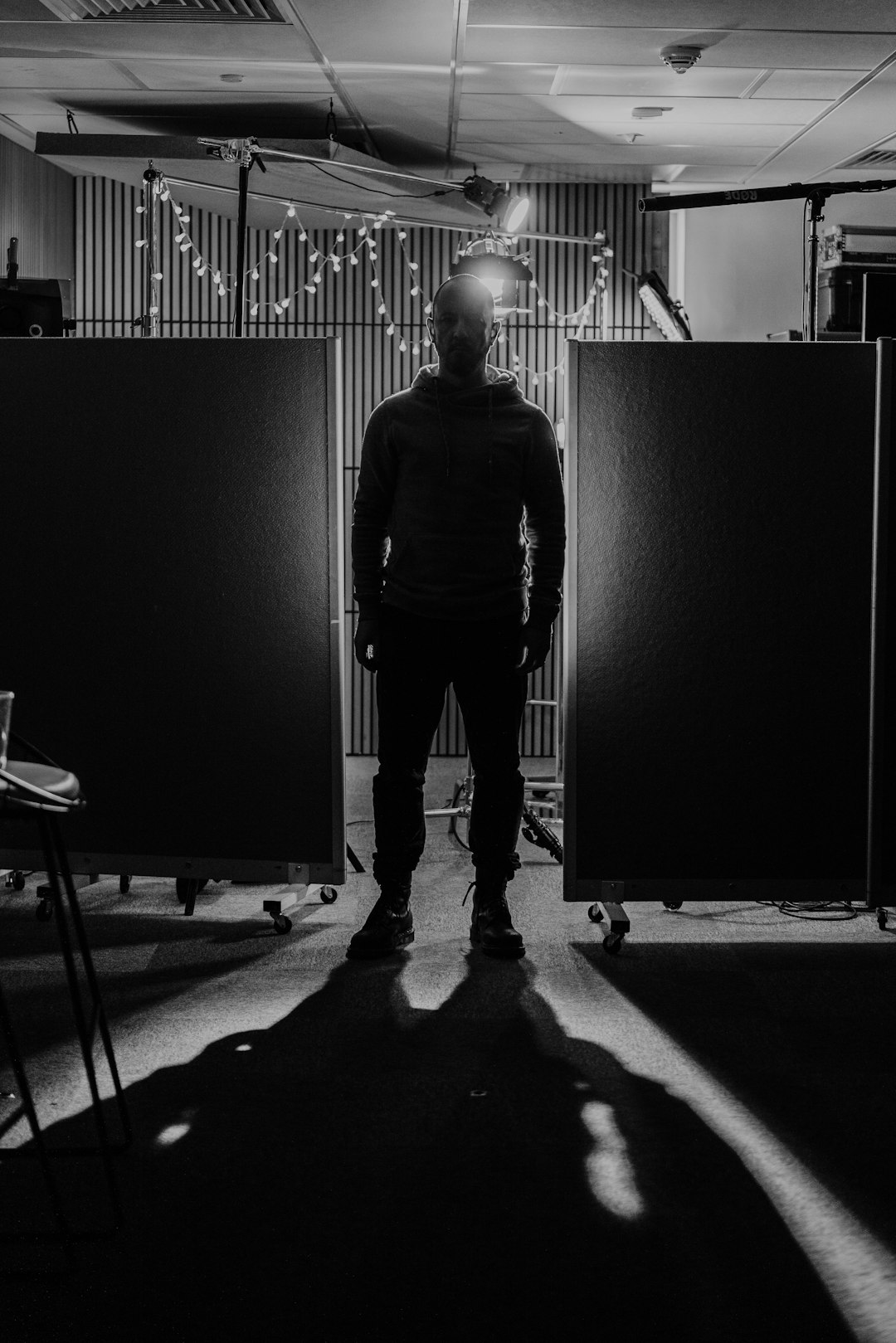 man-standing-between-two-dark-panels-with-lights-kdduzomimkk